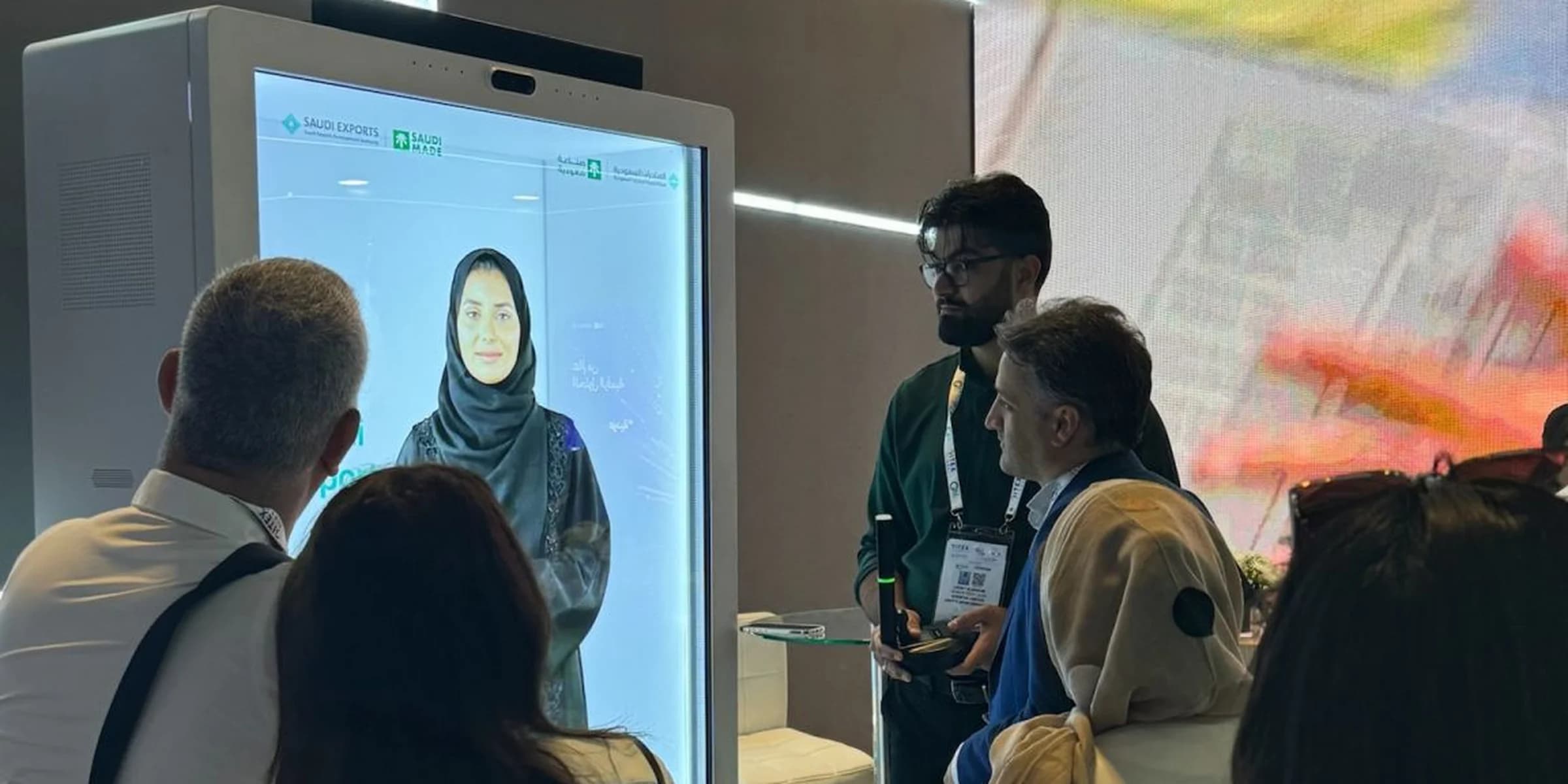 Visitors at the Saudi Exports stand speaking with the Holobox bilingual AI avatar